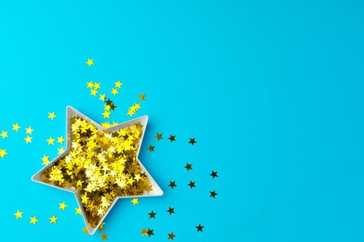 Star shaped plate with golden confetti top view copy space