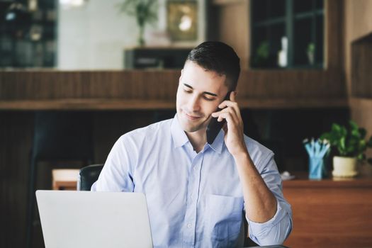 Male marketing manager using phone to talk to venture capital firm to increase profit potential