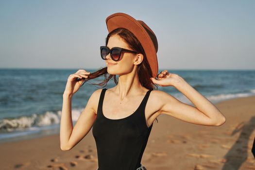 woman in a hat sunglasses by the ocean travel sun. High quality photo