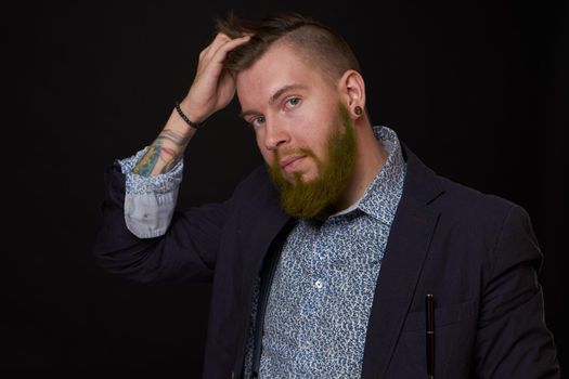 fashionable business man in a jacket with a beard posing. High quality photo