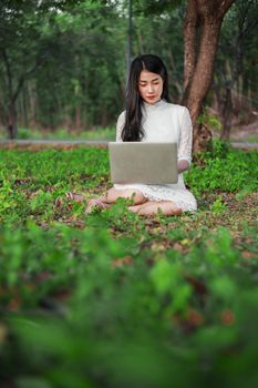 beautiful woman using laptop in the outdoor park