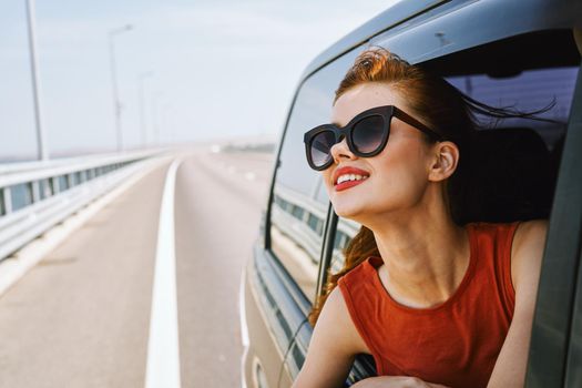 woman looking out of car window wearing sunglasses travel lifestyle. High quality photo