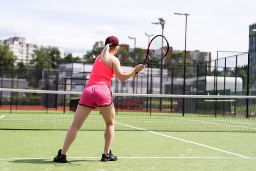 Woman playing tennis and waiting for the service