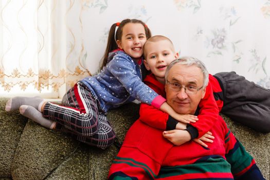 Grandparents spending time with grandchildren on couch