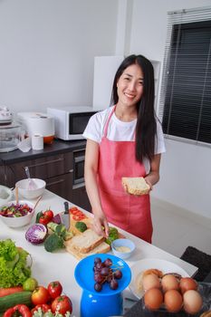 woman preparing a sandwich in kitchen room at home