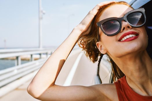 cheerful woman peeking out of the car window trip adventure lifestyle. High quality photo