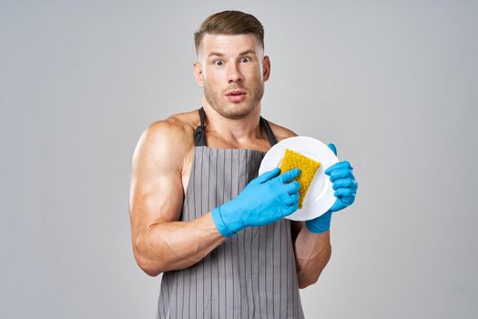 a man in an apron washes the dishes service housework. High quality photo