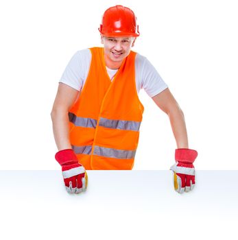 happy working man in a helmet holding a white blank with space for text