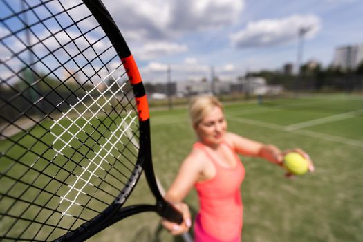 Woman playing tennis holding a racket and smiling