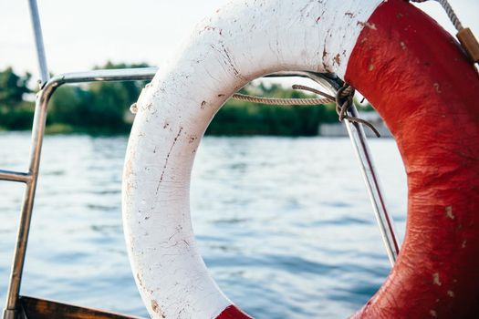 old lifebuoy in red and white on board the yacht