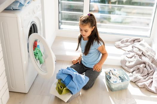 Little girl doing laundry. Housework concept.