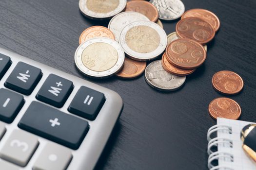 avings, finances, economy and home concept - close up of calculator counting money and making notes at home