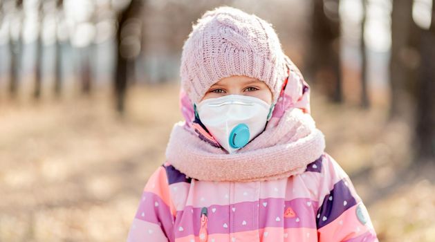 Prety little girl in medical mask on nature background