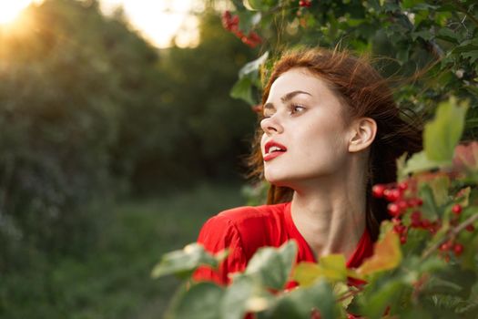 pretty woman in red shirt nature green leaves summer. High quality photo