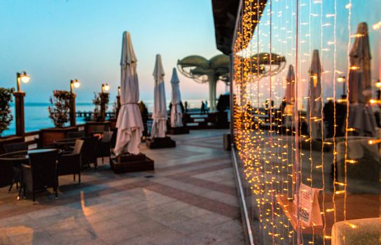 Soft focus. Restaurant terrace at sunset without people. Blinking blur background.