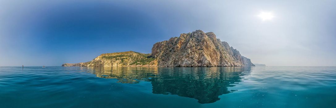 Yachts in the Sea on a background of rocky shores. Sea landscape with yachts and rocky coastline. Copy space. The concept of an travel, relax, active and healthy life in harmony with nature.