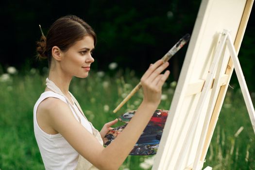 cheerful woman artist painting a picture outdoors creative art. High quality photo