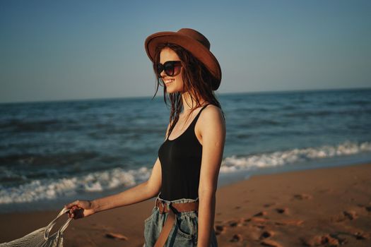 pretty woman in hat walking on the beach ocean travel. High quality photo