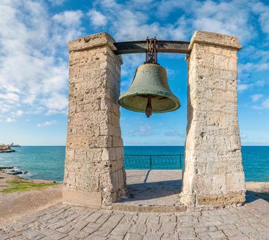 Big bronze bell on the sea shore in the ancient Greek city Chersonesus, Hersones in Sevastopol, Crimea. Copy space. Travel and relax concept