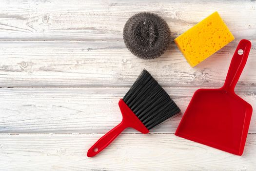 Home cleaning supplies on white wooden background, top view photo