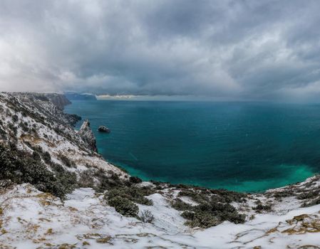 Winter sunset over the sea bay from the height of overhanging cliffs. Cape Fiolent in Balaklava, Sevastopol, Crimea.The concept of calm, silence and unity with nature