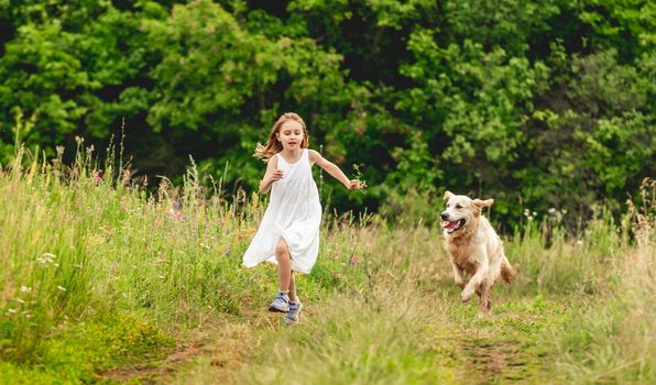 Girl kid with cute dog running on summer nature