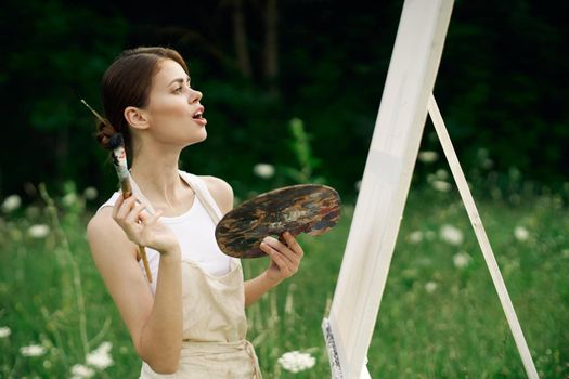 woman outdoors paint a picture landscape hobby creative. High quality photo