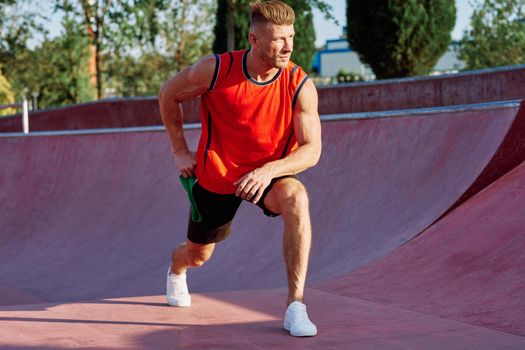 athletic man on the sports ground rubber band exercise. High quality photo