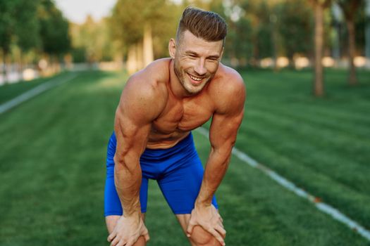 sporty man with pumped up body in park workout exercise. High quality photo