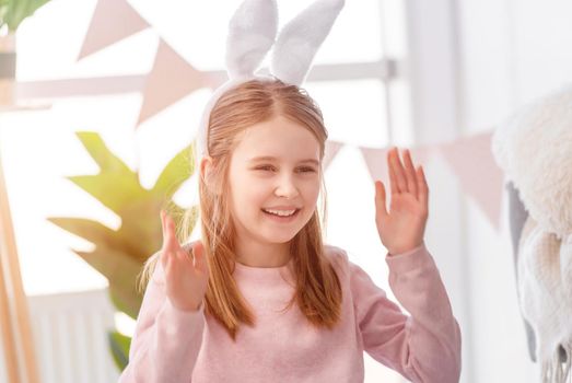 Little beautiful girl smiling in sunny room decorated for Easter day