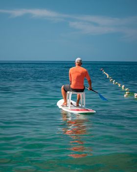 Strong men floating on a SUP boards on a sunny day