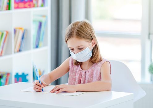 Schoolgirl studying in class wearing face mask during pandemic