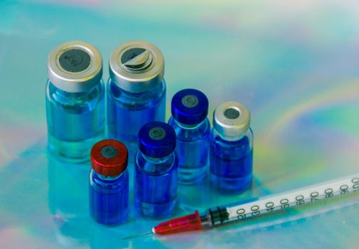 close up group of vaccine vials and syringe