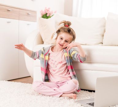 Happy smiling little girl recording video with headphones on