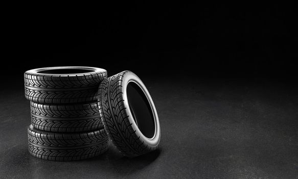 Four car tires on the asphalt on a black background, 3D rendering illustration.