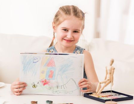 Little girl showing her beatiful drawing, made with dry pastel