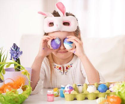 Pretty little girl playing with her colorful Easter egg collection