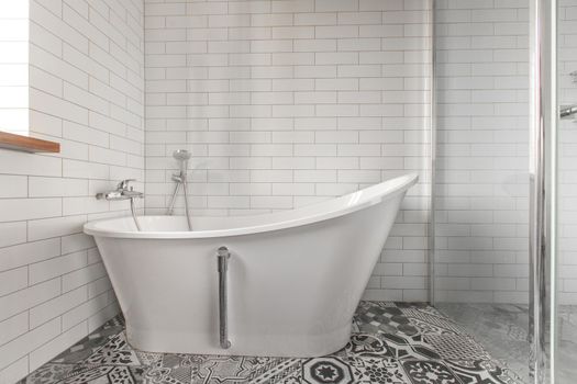 White bathroom on a tiled wall background Classic bathtub