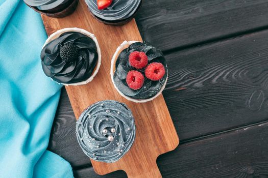 Close up of some decadent gourmet cupcakes frosted with a variety of frosting flavors