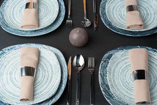 Table setting. Plates with abstract pattern on black table. High quality photo