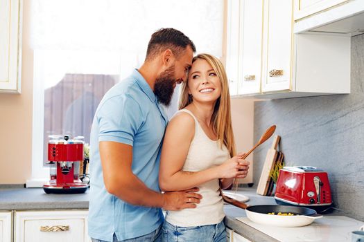 Young loving couple cooking together in kitchen at home