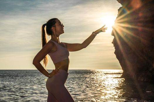 Girl gymnast is training on the beach by the sea sunset. Does twine. Photo series