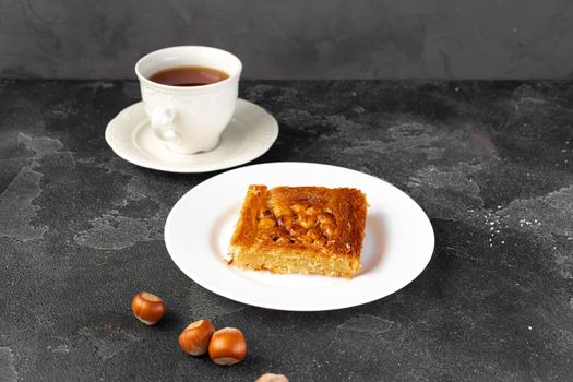 Turkish dessert baklava with nuts on black background, close up