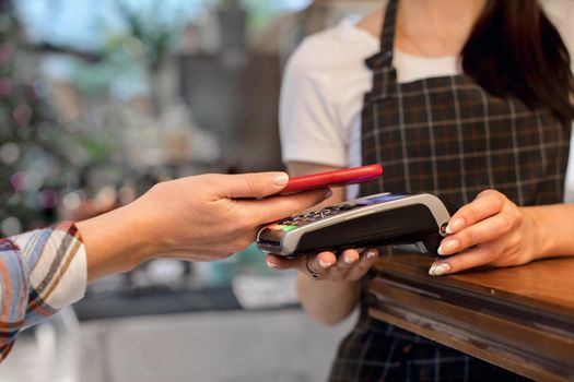 A woman pays for an account with a credit card in her phone