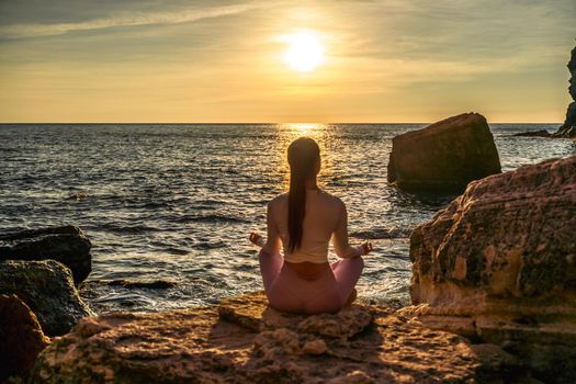 Young woman practicing yoga outdoors. Harmony and meditation concept. Healthy lifestyle.