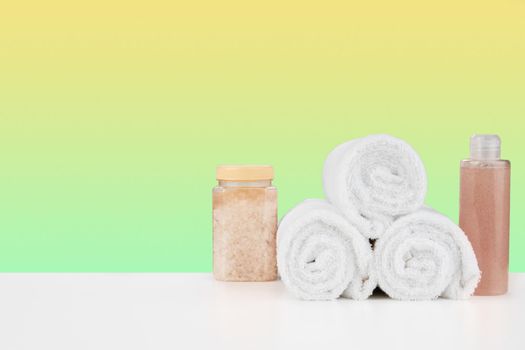 Bath towels and spa salt on white table, close up