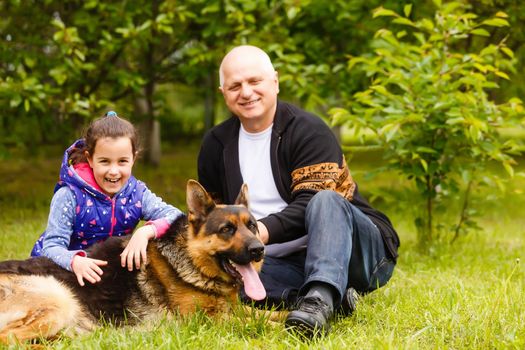 Grandfather And Granddaughter Taking Dog For Walk