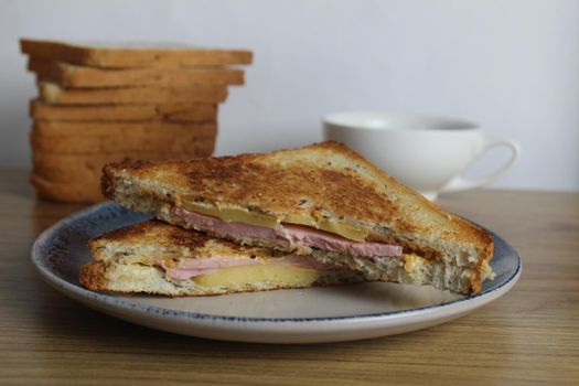 Food, avtrak. Sandwiches with ham cheese and vegetable elenium lie on a gray plate next to the juice of orange apricot on the table. Cooking breakfast.