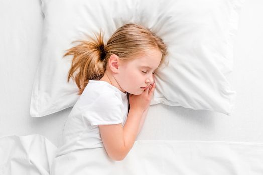 cute little girl with toy sleeping in white bed