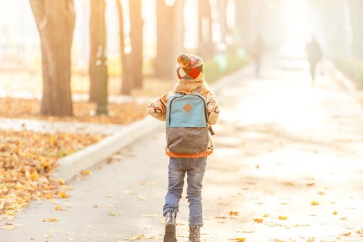 Back view of little girl going from school